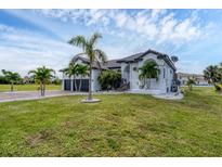 A beautiful two-story house with a well-manicured lawn and lush tropical landscaping at 24017 Peppercorn Rd, Punta Gorda, FL 33955