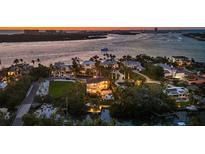 Scenic aerial view of a waterfront neighborhood with boats on the water and stunning sunset at 3465 Gulfmead Dr, Sarasota, FL 34242