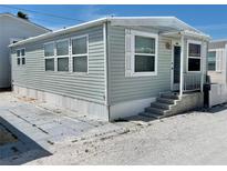 Charming single-story home featuring light green siding, white trim, and a welcoming front porch at 3710 Gulf Of Mexico Dr # A20, Longboat Key, FL 34228
