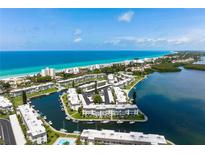 Stunning aerial view of beachfront condos and marina, offering a picturesque coastal lifestyle with boat access at 4380 Exeter Dr # H202, Longboat Key, FL 34228