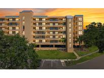 A beautiful condo complex with balconies and palm trees set against a vibrant sunset sky at 4410 Fairways Blvd # 605, Bradenton, FL 34209