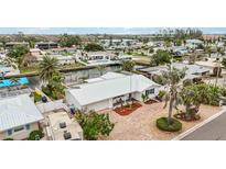 Beautiful waterfront home with a metal roof and a paved driveway in a coastal community at 10308 Kingfisher W Rd, Bradenton, FL 34209