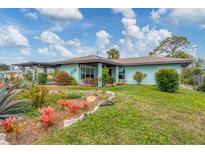 Quaint single-story home with a well-manicured front lawn, garden, and inviting curb appeal at 1156 Lemon Bay Dr, Venice, FL 34293