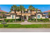 Inviting two-story home with palm trees and manicured landscaping creating a welcoming curb appeal at 141 Bella Vista Ter # 34D, Nokomis, FL 34275