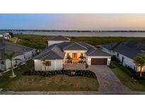 Beautiful waterfront home with a brick driveway, manicured lawn, and picturesque ocean view at 1613 4Th E St, Palmetto, FL 34221