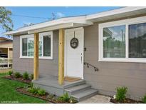 Charming home featuring a cozy front porch with natural wood supports and gray painted steps at 1813 5Th W St, Palmetto, FL 34221