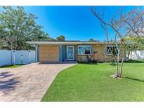 Charming single-story home with a brick driveway, lush green lawn, and well-maintained landscaping at 216 Archer Way, Anna Maria, FL 34216