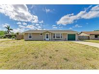 Charming single-story home featuring a well-maintained lawn and a cheerful green garage door at 3119 40Th W Ave, Bradenton, FL 34205