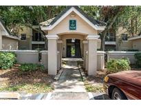 Inviting entryway to the condo building featuring shade trees and well maintained landscaping at 5134 Northridge Rd # 106, Sarasota, FL 34238