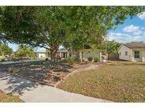 Charming home with a large tree and landscaped front yard at 5728 Whistlewood Cir, Sarasota, FL 34232