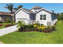 Charming single-Gathering home featuring a well-manicured lawn, and a driveway leading to the garage at 6228 Champions Row St, Bradenton, FL 34210