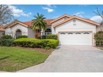 Charming single-story home with a well-manicured lawn, a two-car garage, and a red tile roof at 8824 Havenridge Dr, Sarasota, FL 34238