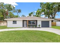 Newly renovated single-story home featuring a gray accent wall, freshly painted white exterior, and a well-manicured front lawn at 1050 55Th S Ave, St Petersburg, FL 33705