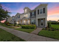 Beautiful townhome showcasing manicured landscaping and a charming, symmetrical facade at dusk at 12029 Cranston Way, Lakewood Ranch, FL 34211