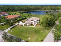 Stunning aerial view of a beautiful home with a lush green lawn and serene lake in a peaceful neighborhood at 3607 Twin Rivers Trl, Parrish, FL 34219