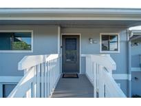 Inviting gray condo entryway with white railings, leading to the front door with visible unit number at 6033 34Th W St # 132, Bradenton, FL 34210