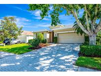 Charming single-Gathering home featuring a well-manicured lawn, paver driveway, and mature landscaping under a bright blue sky at 6729 45Th E Ter, Bradenton, FL 34203