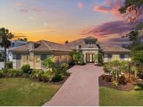 Stunning home with a terracotta-tiled roof, brick drive, and well manicured landscaping at 72 Grande Fairway, Englewood, FL 34223