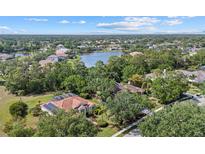 Expansive aerial view of a home nestled among lush trees and overlooking a serene lake in a tranquil neighborhood at 7602 Partridge Street Cir, Bradenton, FL 34202