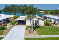 Well-maintained single-story home featuring a covered carport and a partial lake view at 8467 Imperial Cir, Palmetto, FL 34221