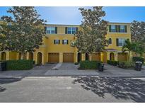 Charming yellow townhouse featuring well-maintained landscaping, multiple garage doors, and decorative shutters at 8827 White Sage Loop, Lakewood Ranch, FL 34202