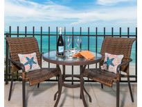 Relax on this condo balcony and enjoy ocean views while seated at the table with seating for two at 1212 Benjamin Franklin Dr # 901, Sarasota, FL 34236