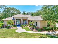 Charming single-story home featuring lush landscaping, blue door, and a welcoming walkway at 14104 E 22Nd Ter, Bradenton, FL 34212