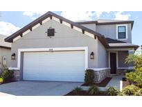 Charming two-story home featuring a pristine white garage door and a neatly landscaped yard at 16134 Paynes Mill Dr, Bradenton, FL 34211