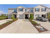 Charming townhome with attached garages and long driveway, enhanced by lovely landscaping and mature trees at 17620 Crescent Moon Loop, Bradenton, FL 34211