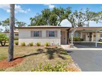 Charming single-story home featuring a carport, well-maintained landscaping, and light-colored exterior at 2819 Swifton Dr # 9, Sarasota, FL 34231