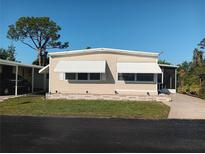 Charming single-story home with awnings, brick foundation, and a well-maintained lawn at 320 Tropic Dr, Osprey, FL 34229