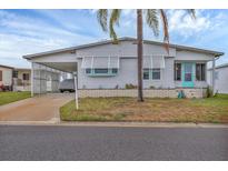 Charming single-story home featuring a covered carport, turquoise door, and tropical landscaping at 4312 14Th E St, Ellenton, FL 34222