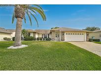 Charming home featuring a well-manicured lawn and a decorative palm tree in the front yard at 4360 Presidential Avenue E Cir, Bradenton, FL 34203