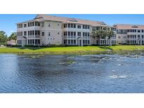 Scenic view of multi-story condos with screened patios overlooking a lily pad filled lake on a sunny day at 4802 51St W St # 1908, Bradenton, FL 34210
