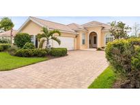 Charming single-story home with a tile roof, arched entryway, brick driveway, and mature landscaping at 5751 Wilena Pl, Sarasota, FL 34238