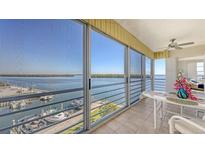 Enjoy waterfront views from this balcony with large sliding glass doors, boat dock views, and a cozy seating area at 600 Sutton Pl # B305, Longboat Key, FL 34228