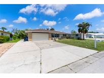 Charming single-story home featuring an attached two-car garage and a well-maintained lawn with palm trees at 609 Glen Oak Rd, Venice, FL 34293