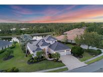 Waterfront home features lush landscaping, screened lanai, brick driveway and three car garage at 7034 Honeysuckle Trl, Lakewood Ranch, FL 34202