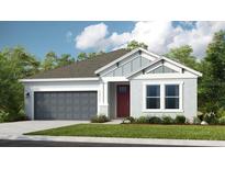 Charming single-story home with a two-car garage, manicured lawn, and inviting front entrance at 7048 Foxboro Way, Nokomis, FL 34275