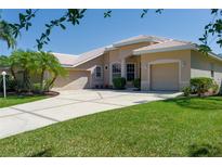 Beautiful single-story home with a well-manicured lawn, mature trees, and a long driveway leading to a three-car garage at 11458 30Th E Cv, Parrish, FL 34219
