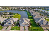 Aerial view of new homes in a community surrounding a scenic lake and community pool at 17827 Cherished Loop, Lakewood Ranch, FL 34211