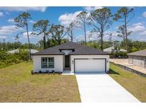 Charming single-story home with a two-car garage and well-manicured lawn at 2290 Beeville Ave, North Port, FL 34286
