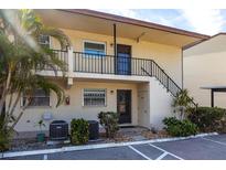 Charming condo exterior featuring a two-story building with well-maintained landscaping and stairs to the second level at 2300 Stickney Point Rd # 125, Sarasota, FL 34231