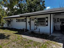 Charming single story home with white painted siding, black shutters, and mature trees at 2503 23Rd W Ave, Bradenton, FL 34205