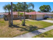 Charming single-story home with a well-manicured lawn and a vibrant orange tile roof at 2536 Carlisle Pl, Sarasota, FL 34231