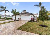 Beautiful single Gathering home featuring a brick driveway, two-car garage, and a well-manicured lawn at 256 Van Gogh Cv, Bradenton, FL 34212