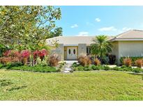 Charming home features a beautifully landscaped front yard, complete with lush green grass and colorful flowerbeds at 3647 Country Place Blvd, Sarasota, FL 34233
