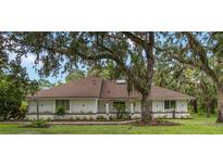 Charming single-story home with a well-maintained lawn and mature trees providing ample shade at 4916 Hidden Oaks Trl, Sarasota, FL 34232