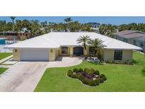 Stunning single-story home with lush lawn, mature palm trees, and white tile roof at 508 70Th St, Holmes Beach, FL 34217