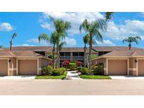 Exterior view of condo with a garage, mature landscaping, well-maintained complex under a partly cloudy blue sky at 5251 Mahogany Run Ave # 521, Sarasota, FL 34241